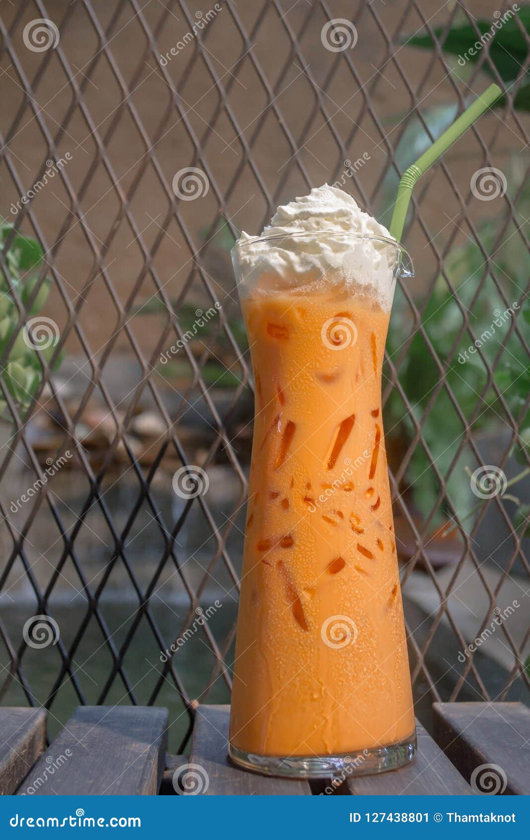 Iced Thai Tea with Whipped Cream Set on the Table Ready To Serve. Stock