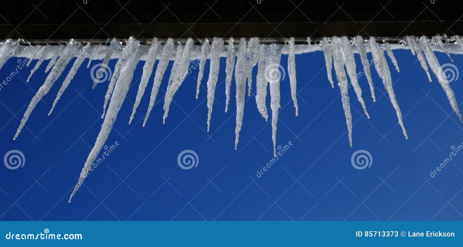 Icicles Hanging from Rooftop of Home Melted Ice Dripping Stock Image
