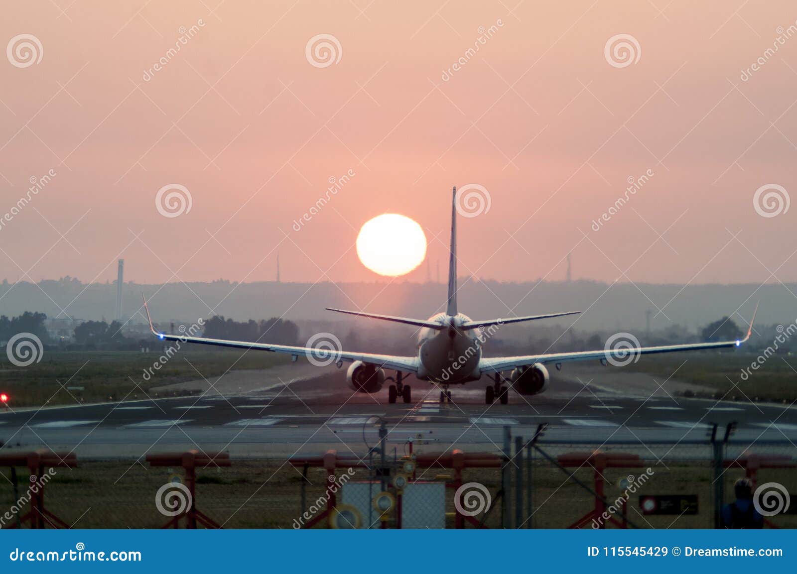 iconical image of airplane landing at an airport at sunset