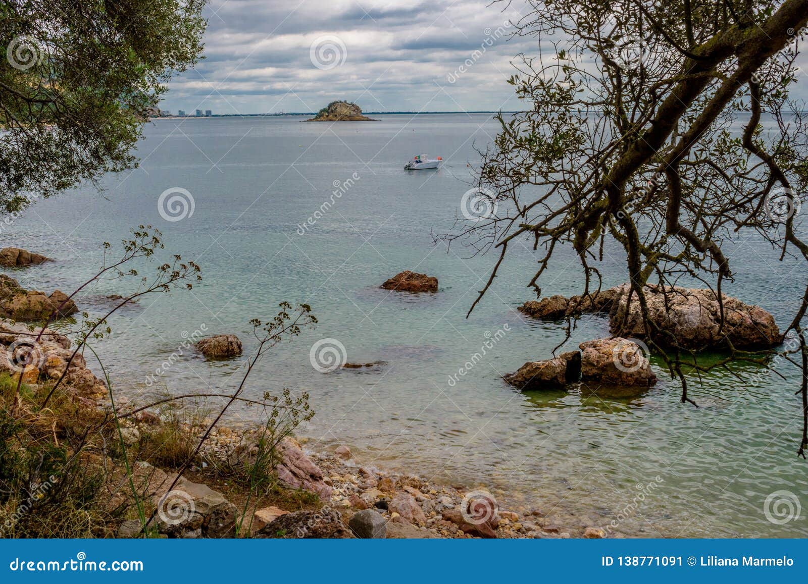idyllic landscape with branches, clear water and recreational boat, creiro beach - serra da arrÃÂ¡bida natural park, setÃÂºbal - por