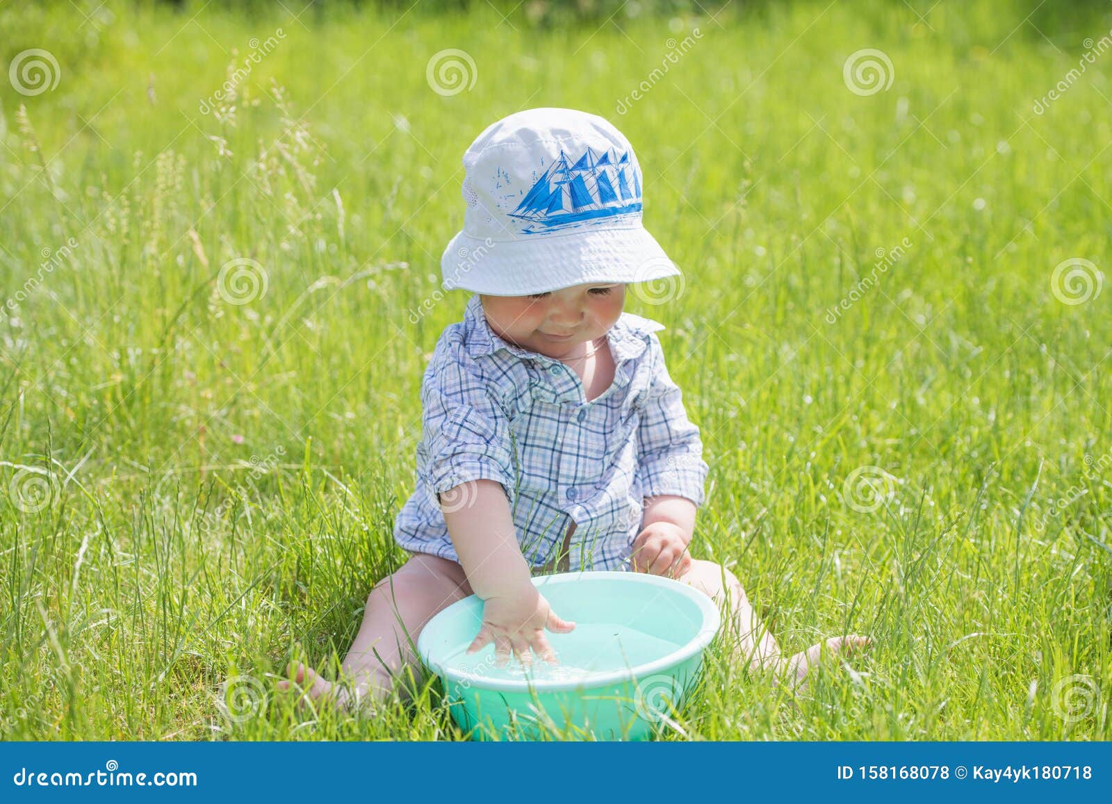 Il Bambino Gioca Con Un Bacino D'acqua Sull'erba Bambino Buffo Che