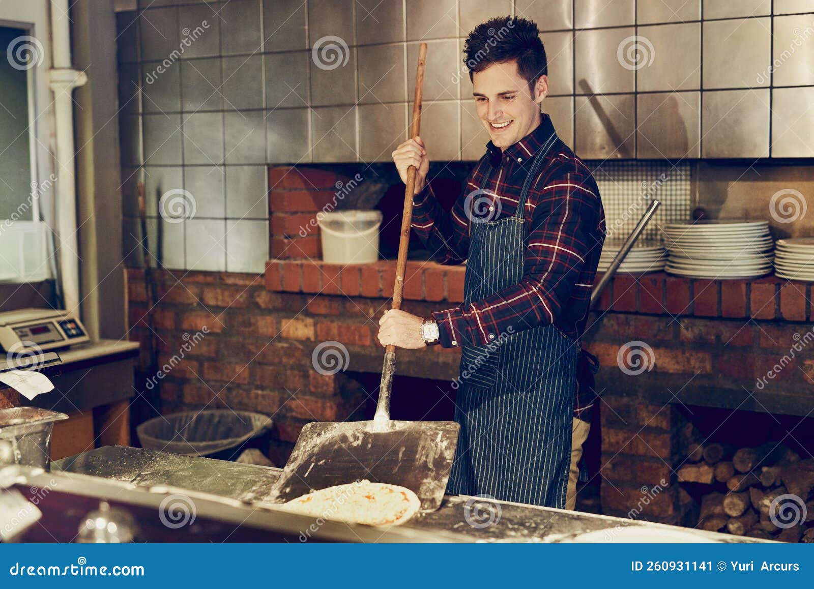 Jeune Homme En Tablier Dans La Cuisine Avec Pizza Maison Prête