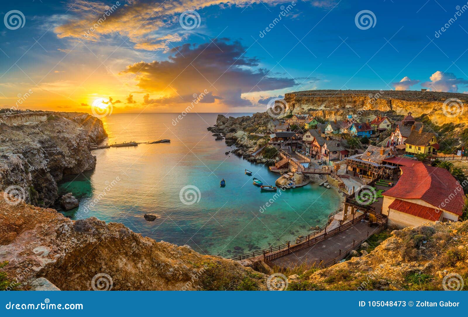 il-mellieha, malta - panoramic skyline view of the famous popeye village at anchor bay at sunset
