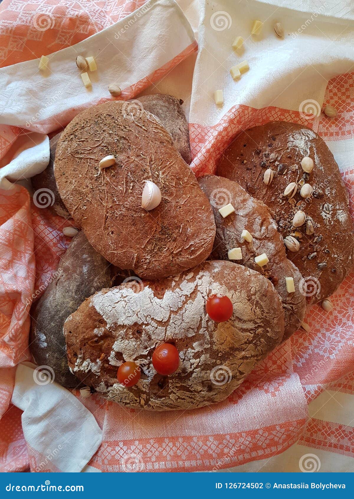 Il pane tradizionale caldo assomiglia al ` s della nonna. Impani fatto a mano su una tovaglia tradizionale di tela, circondata dai pomodori, aglio, pistacchi