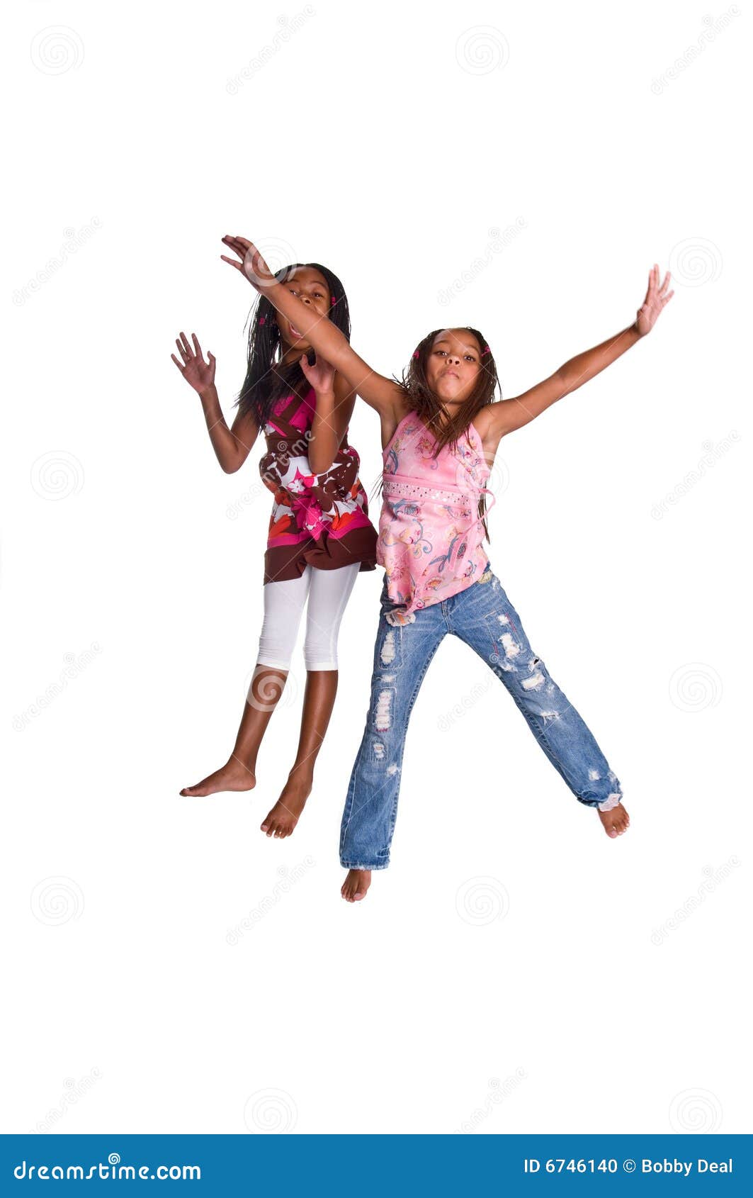 Il salto della ragazza. Due ragazze giovani dell'afroamericano che saltano nell'aria con le braccia outstretchedIsolated sopra bianco
