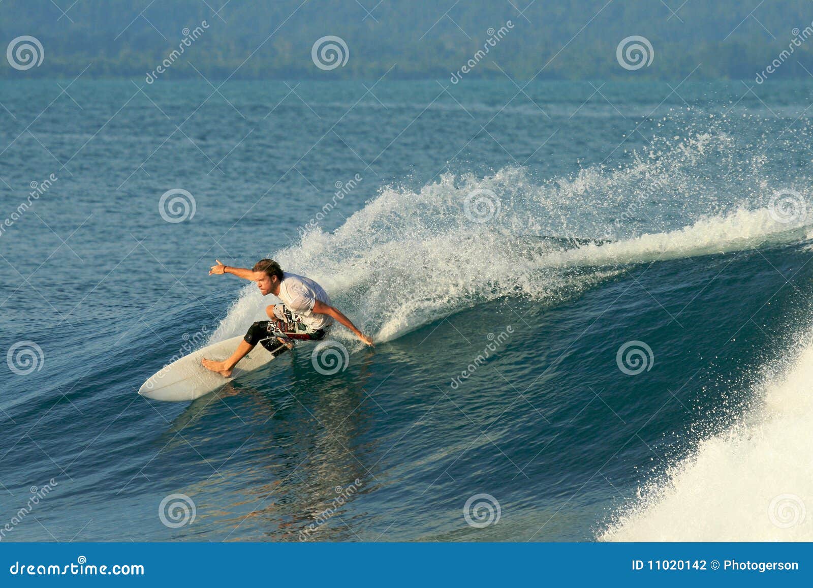 Il surfista che fa la scultura accende l'onda liscia, Mentawai. Surfista che fa intagliando manovra di riduzione sull'onda liscia e gettando spruzzo, isole di Mentawai, Indonesia