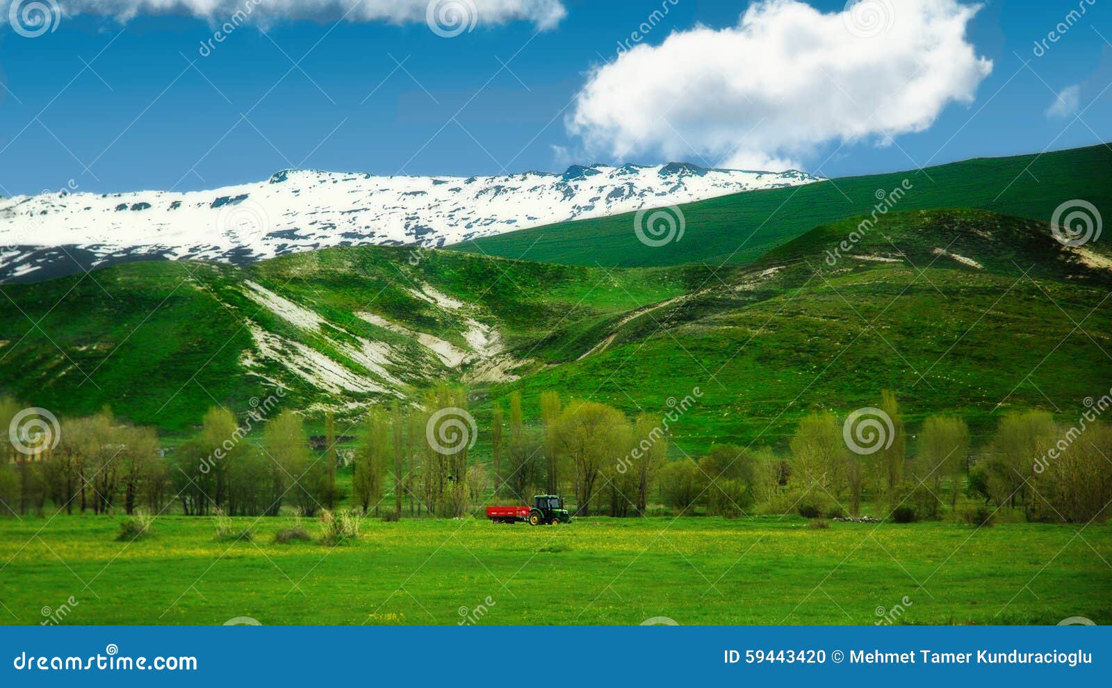 Il trattore rosso sta funzionando nei primi giorni della primavera sull'Anatolia orientale, Turchia fusione della neve e The Creek imbattuto in