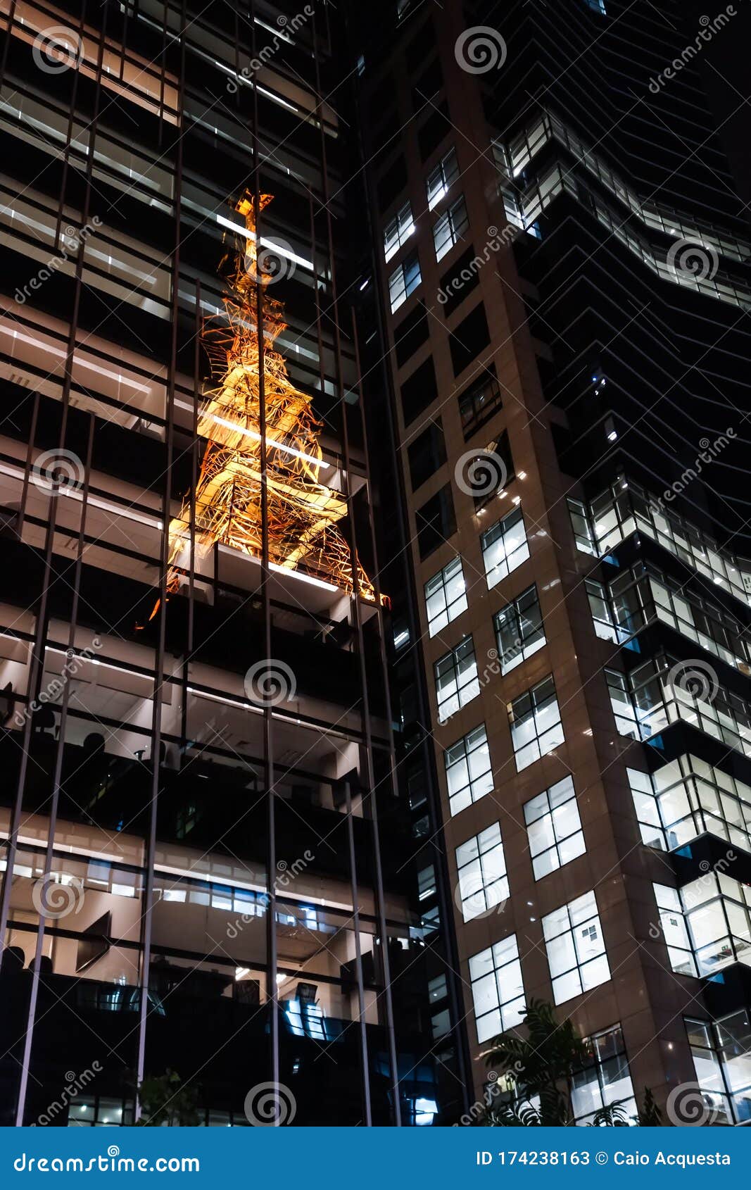 illuminated tower reflecting on the mirrored building facade