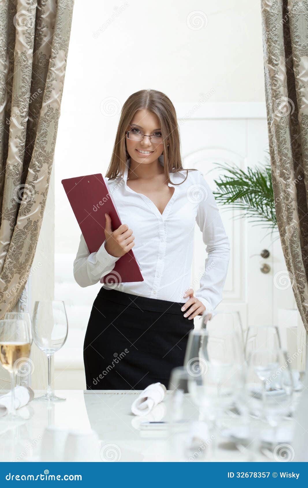 Image of attractive hostess smiling in restaurant