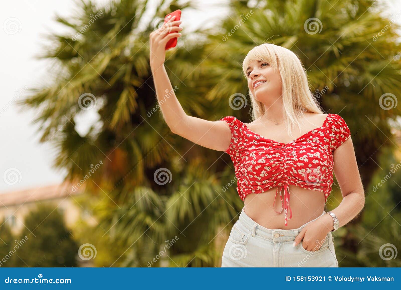 Smiling Blonde Female Person Standing In Park With Blossom 