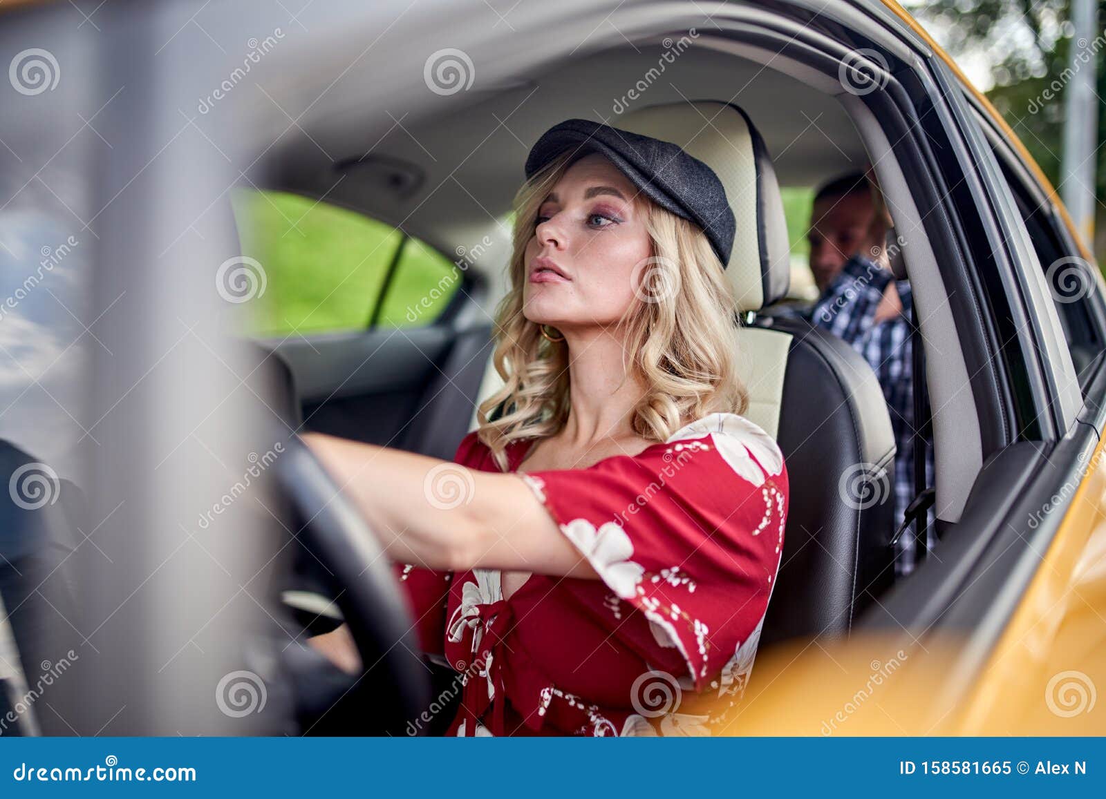 Image Of Blonde Female Driver Driving Male Passenger In Car Stock