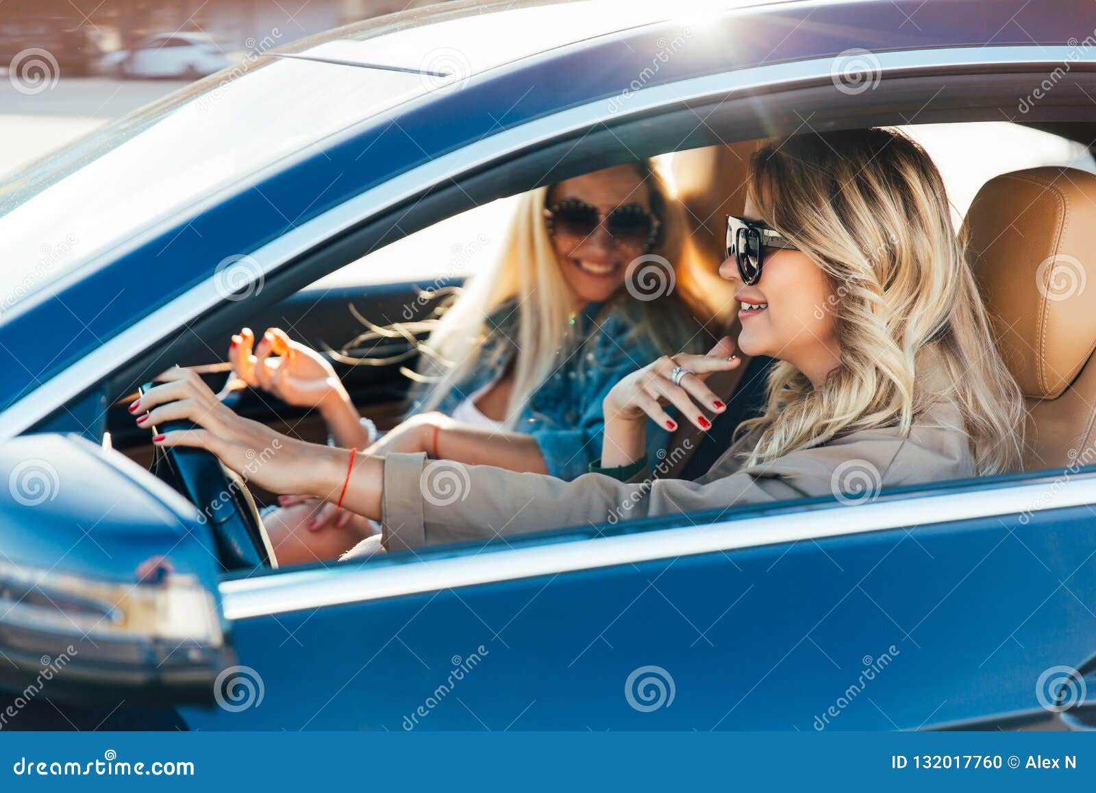 image of blondes wearing sunglasses while driving in car