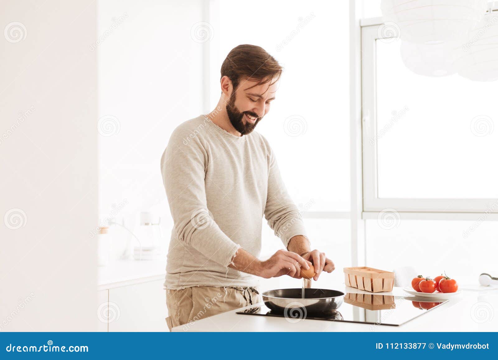 Image of Cheerful Single Man Wearing Casual Clothing Cooking