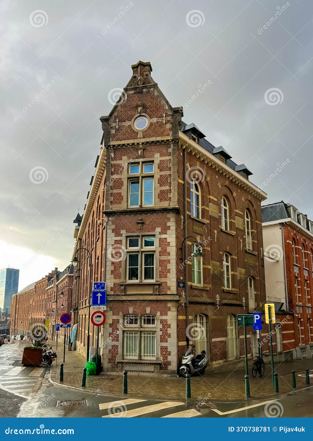 old three-story building in central brussels with brown and red brick facade