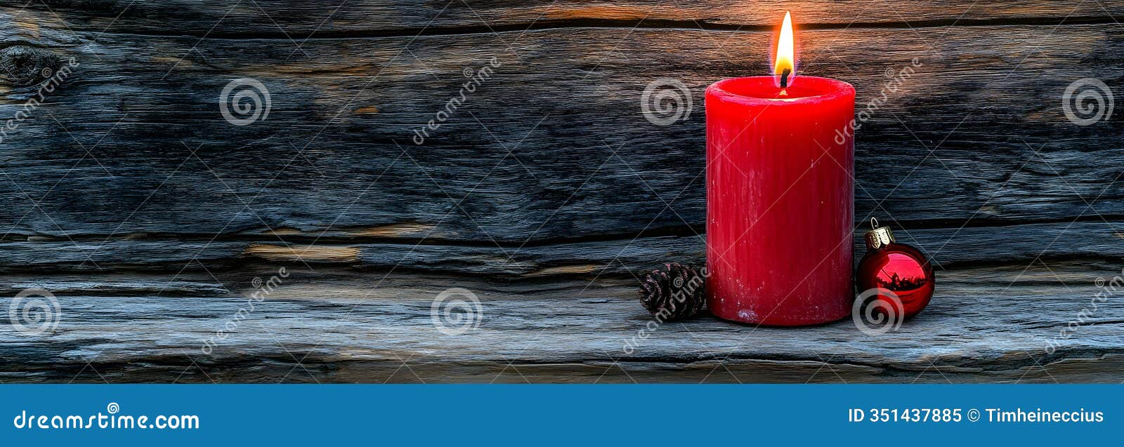 red candle with ornament on wooden background for holiday season decor
