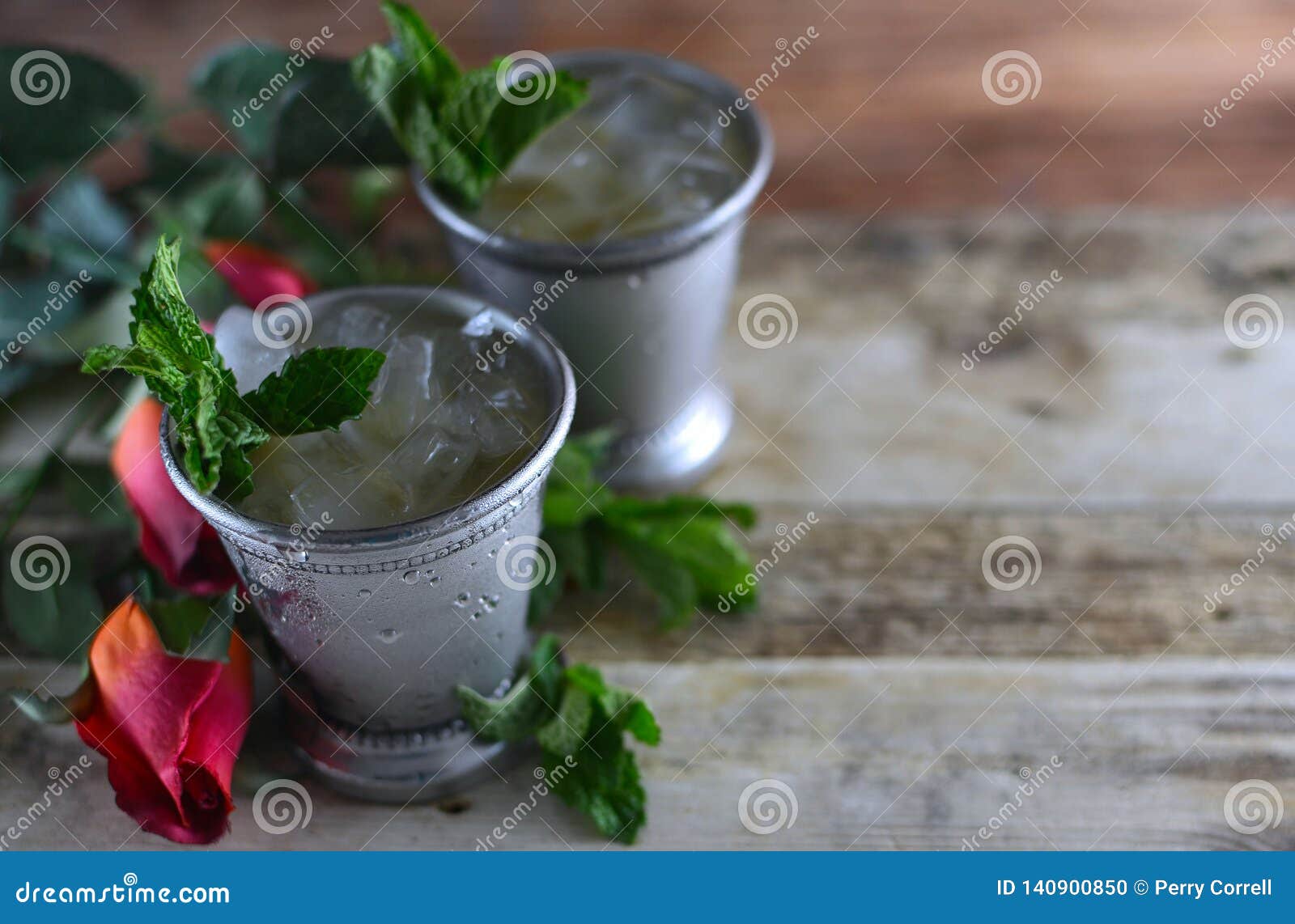 image for kentucky derby in may showing two silver mint julep cups with crushed ice and fresh mint in a rustic setting.