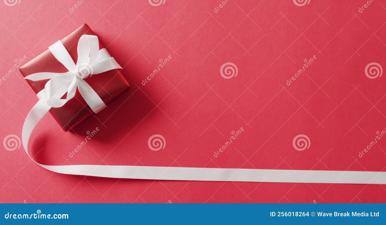 Image of Red Christmas Gift with White Ribbon and Copy Space on Red