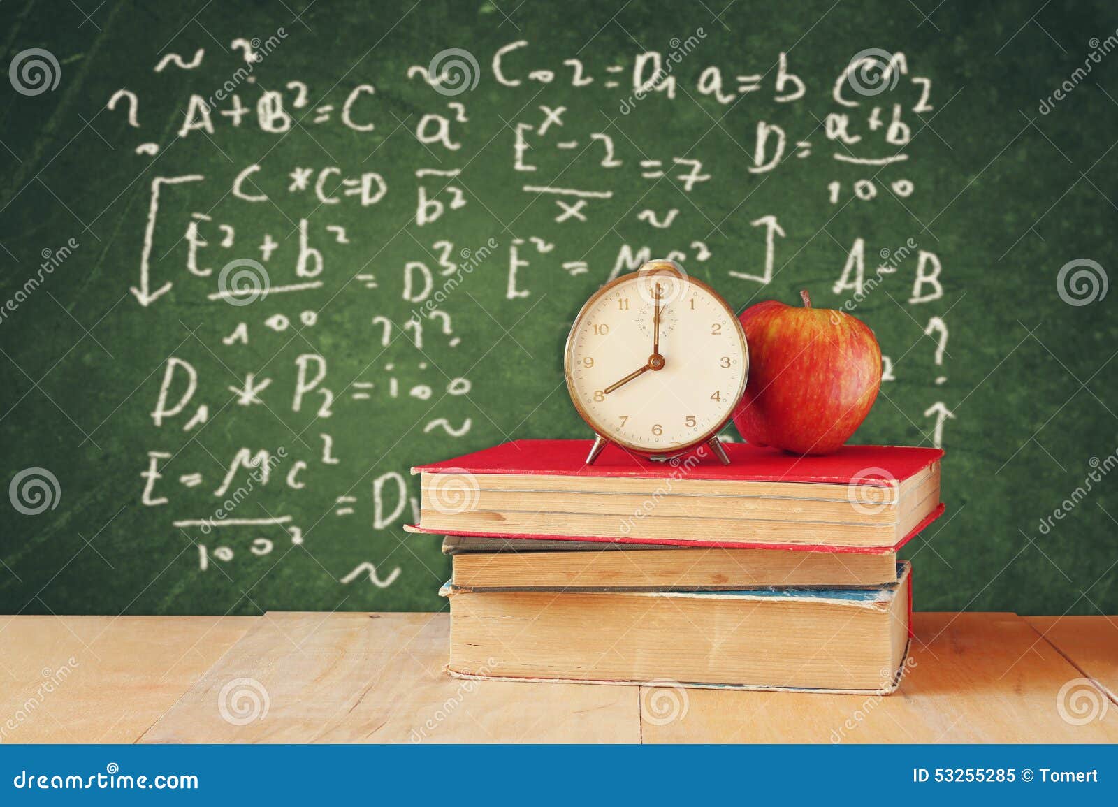 image school books wooden desk apple vintage clock over green background formulas education concept 53255285