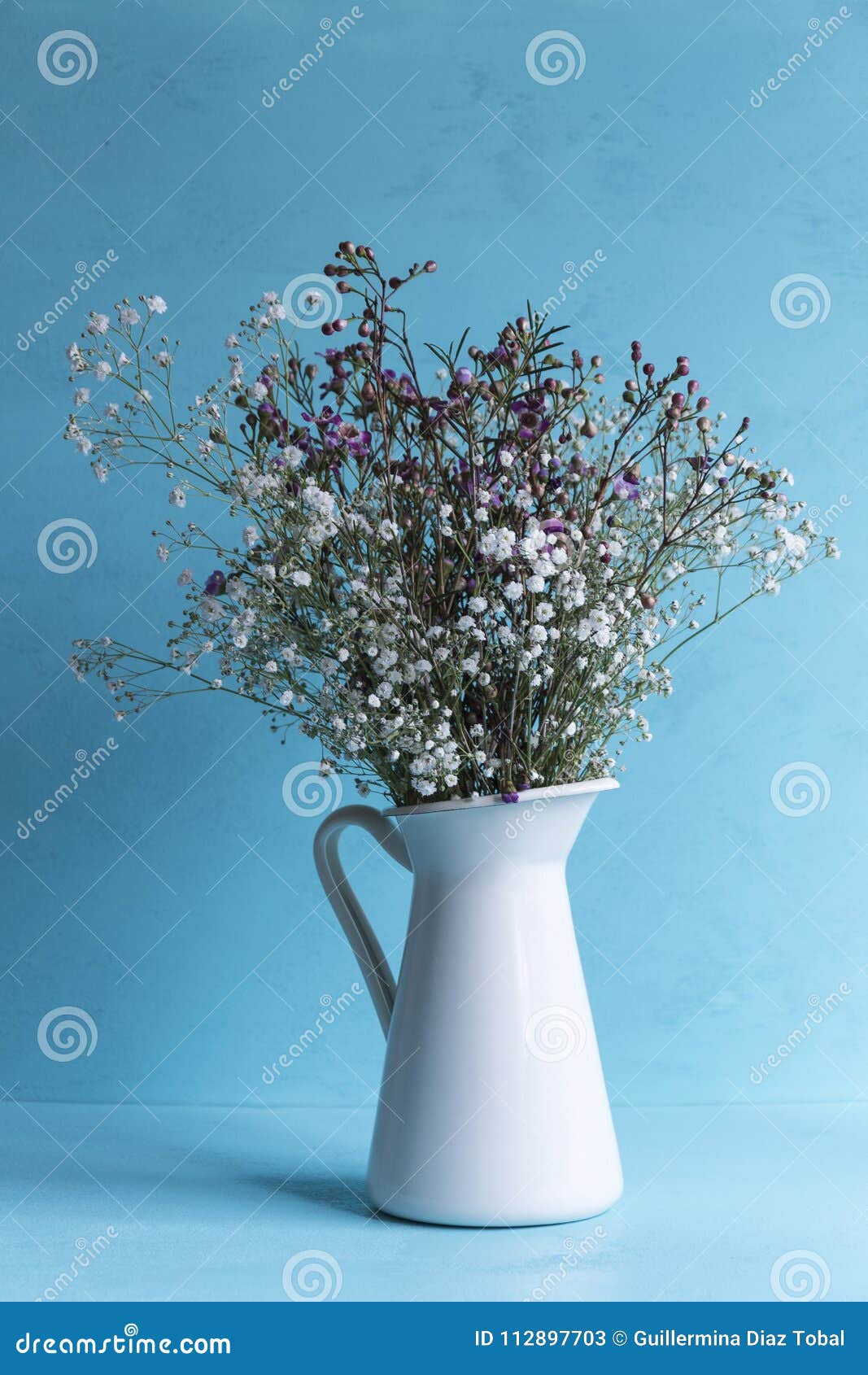 vase with flowers on blue background.