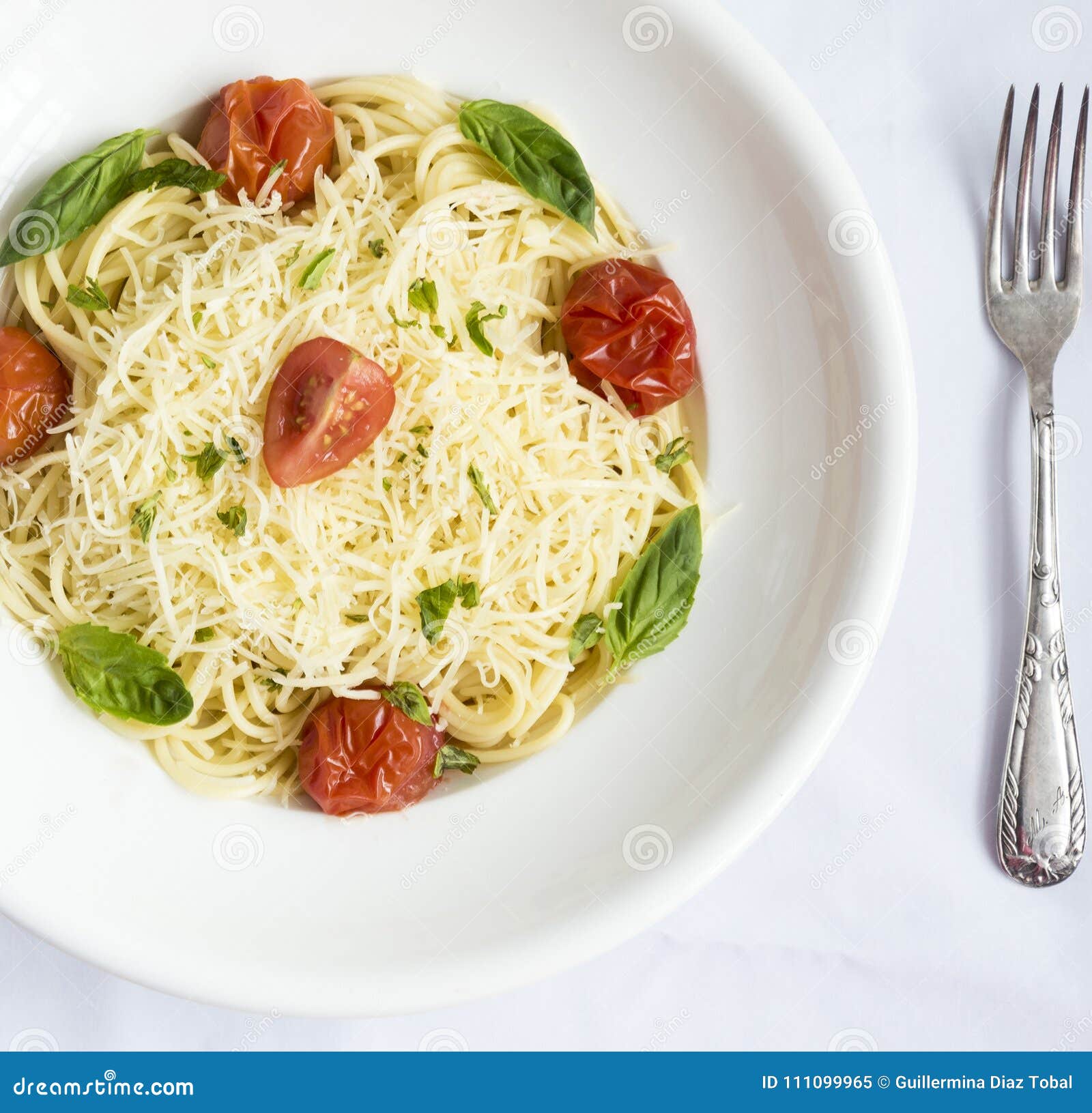 plate of spaghetti with cherry tomatoes, basil and grated cheese