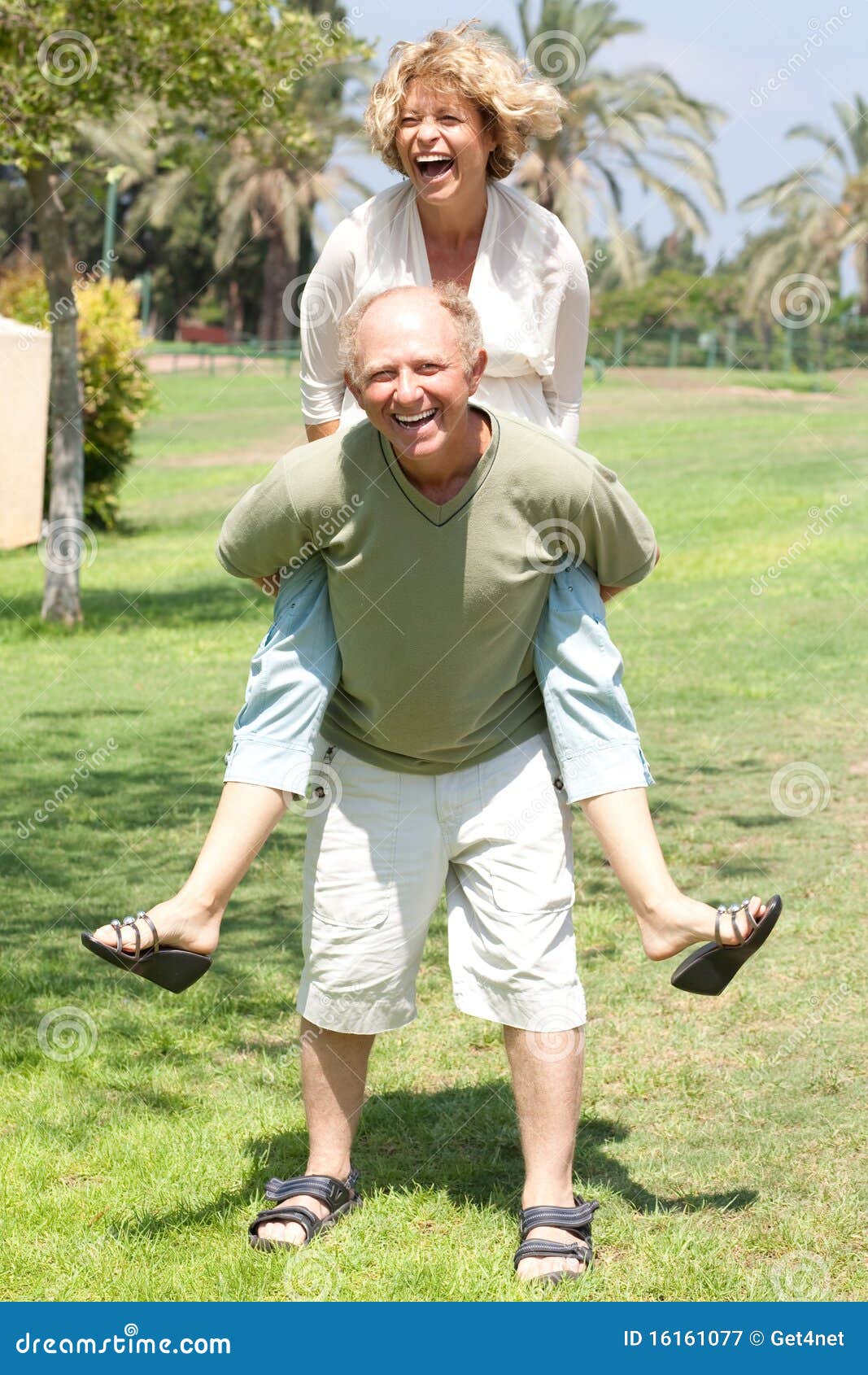 image of senior man giving woman piggyback ride
