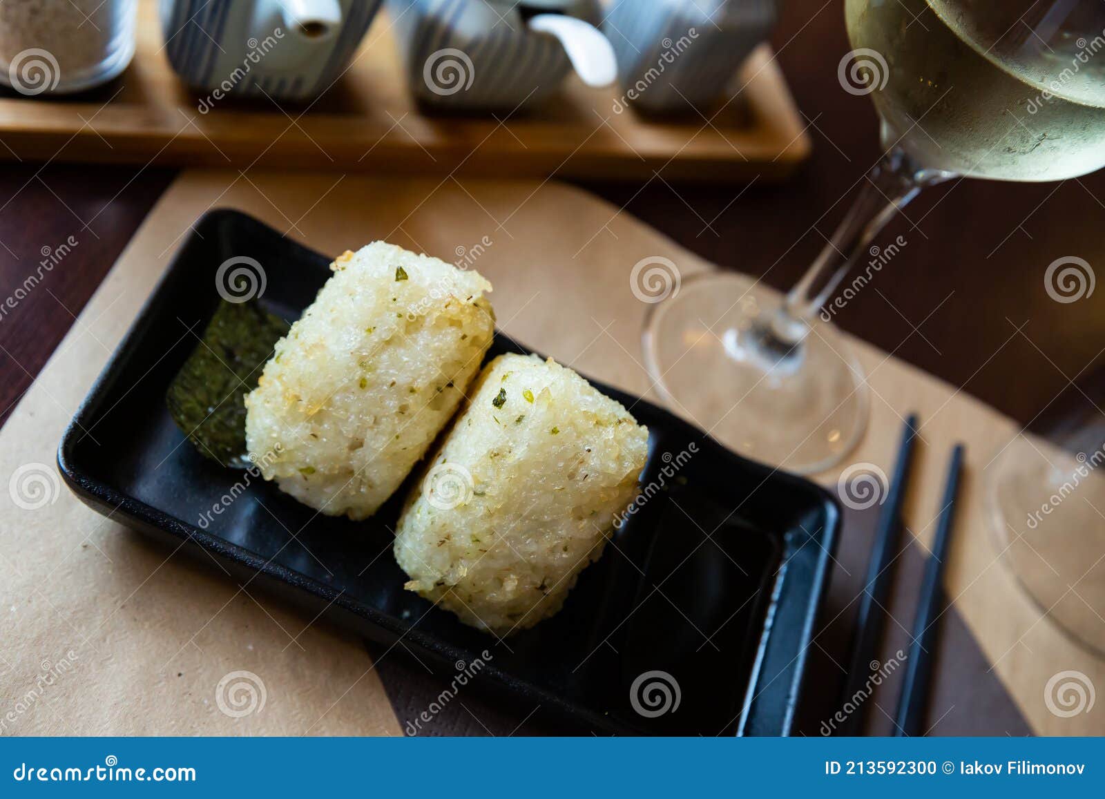 image of tasty triangular onigiri from rice at black plate