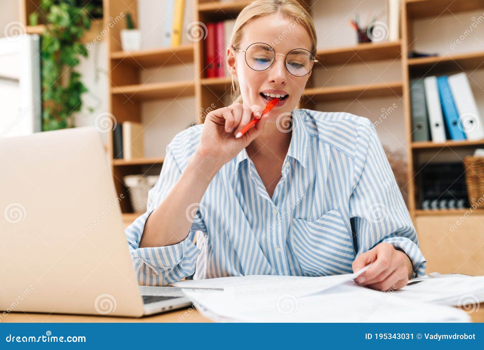 Image of Thinking Woman Writing Down Notes while Working with Laptop ...
