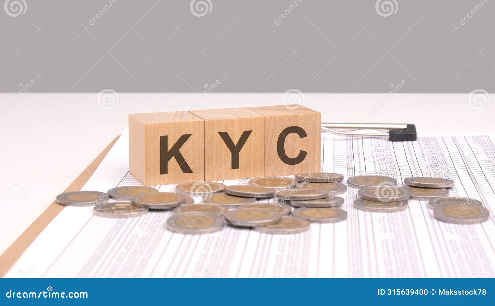 text kyc on wooden cubes on a wooden table with coins. this concept emphasizes the importance of know your client