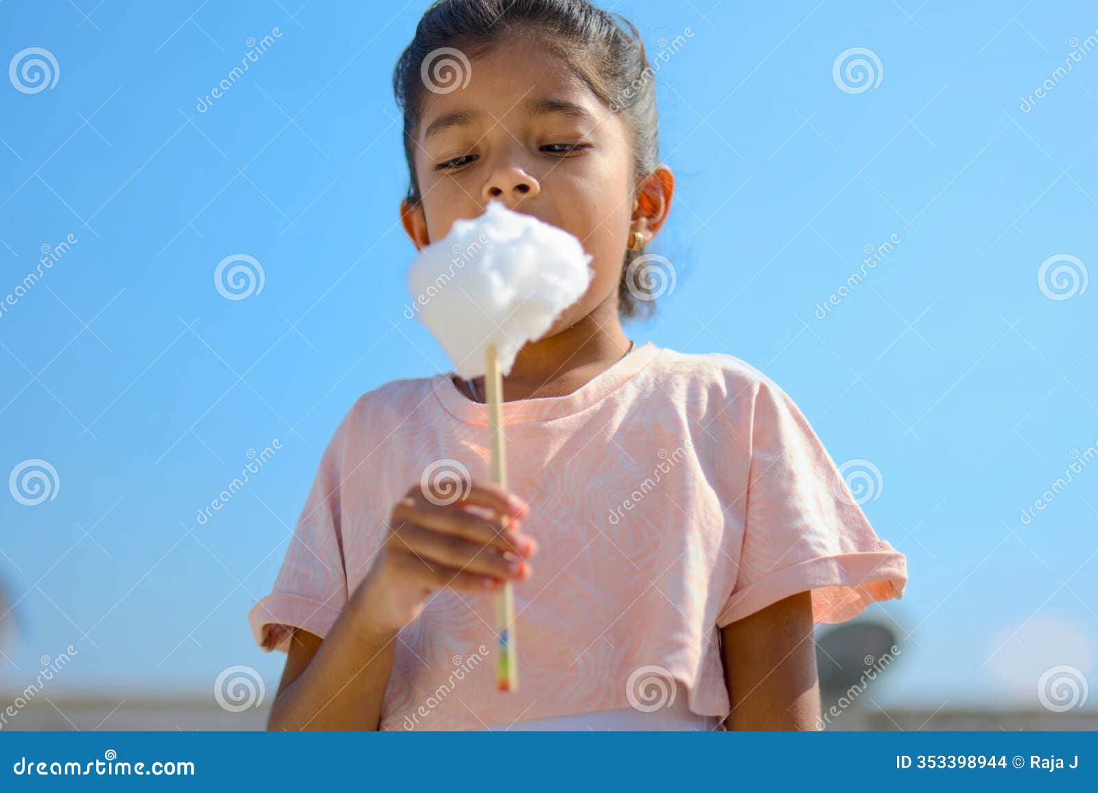 young girl enjoying a sweet treat outdoors on a sunny day. pure delight