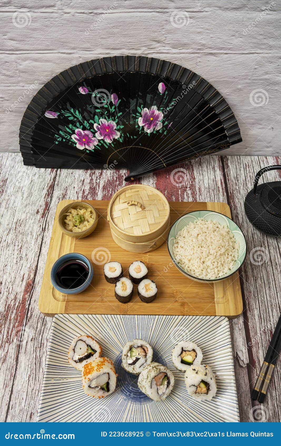 imagen tomada a cuarenta y cinco grados de platos de sushi con abanico negro, ginseng y wasabi, salsa de soja, tablero de bambÃÂº,