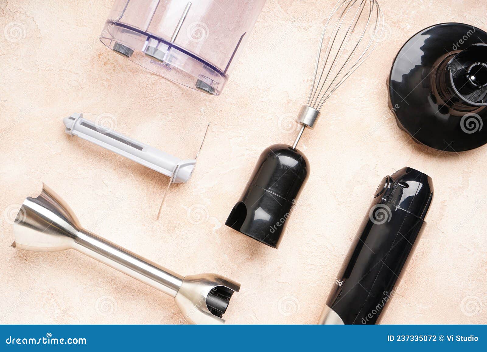 Immersion Hand Blender with Different Attachments on a Beige Background