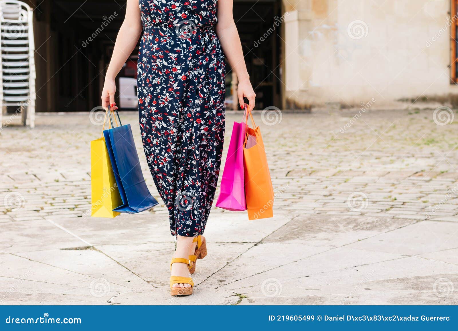 impersonal photo of a shopping woman with colored bags in her hands