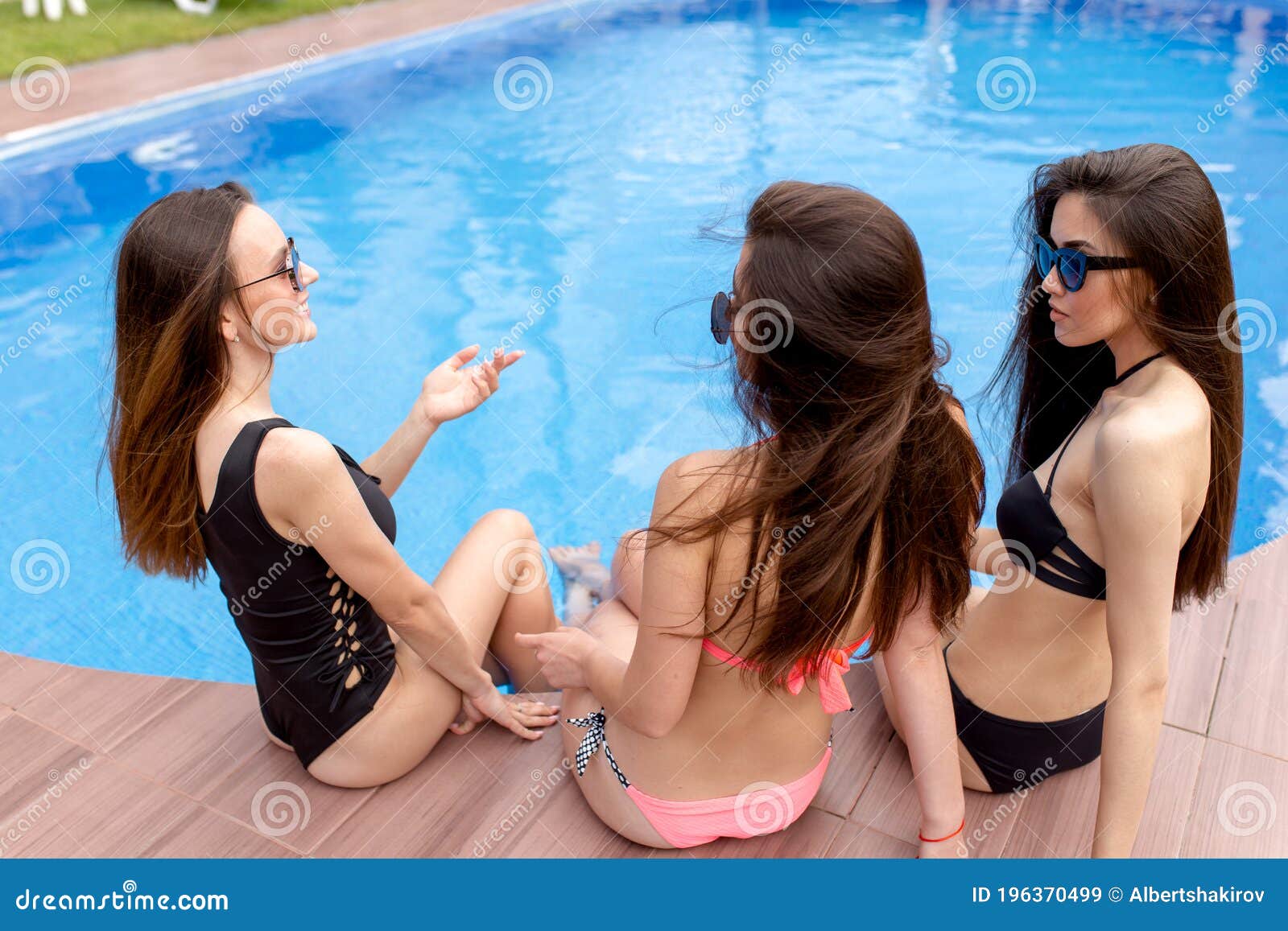 Impresionantes Chicas En Usan Hablar Mientras Están Sentadas En La Piscina de archivo - Imagen de sano,