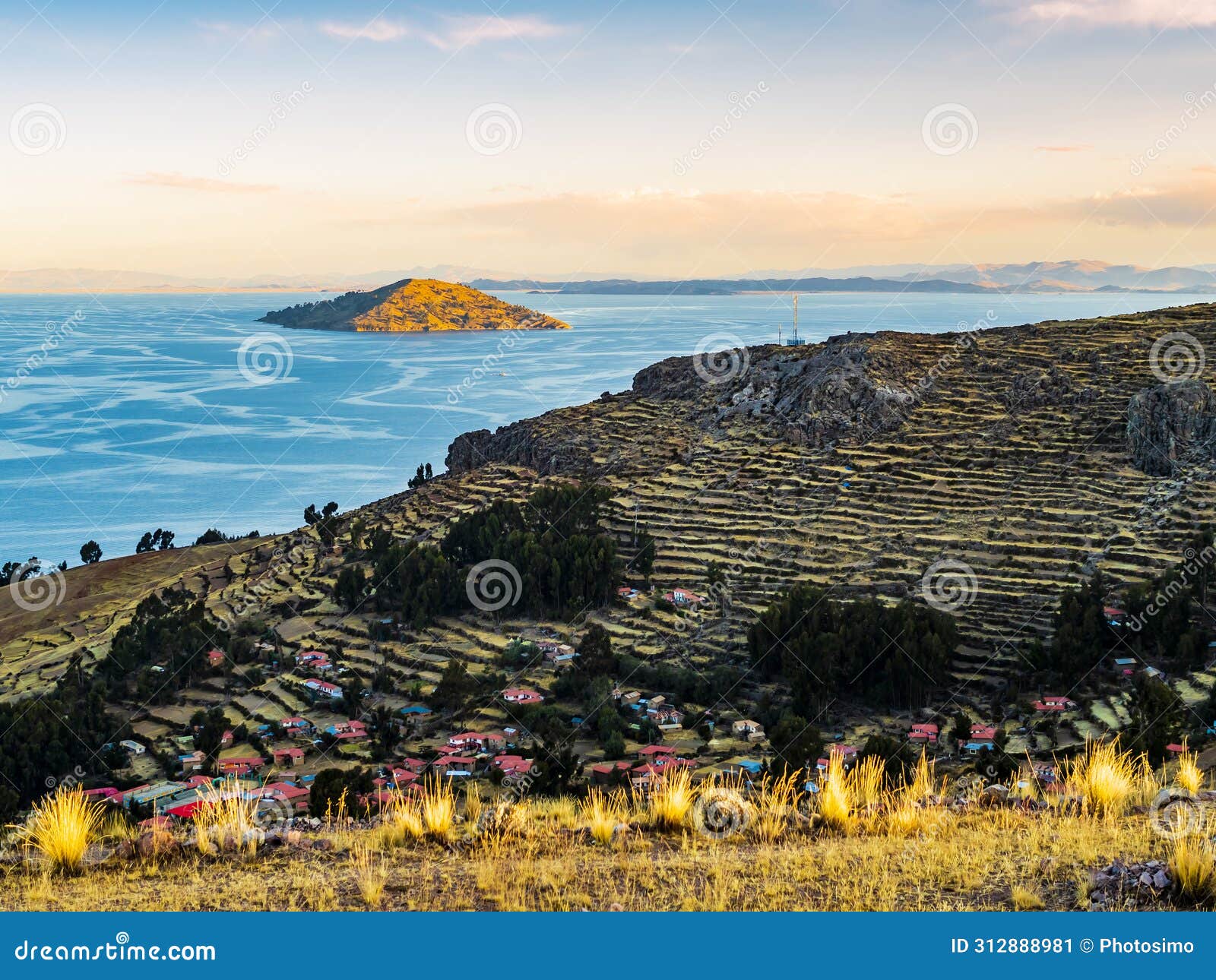 island amantani at sunset with stepped terraced fields, lake titicaca, puno region, peru