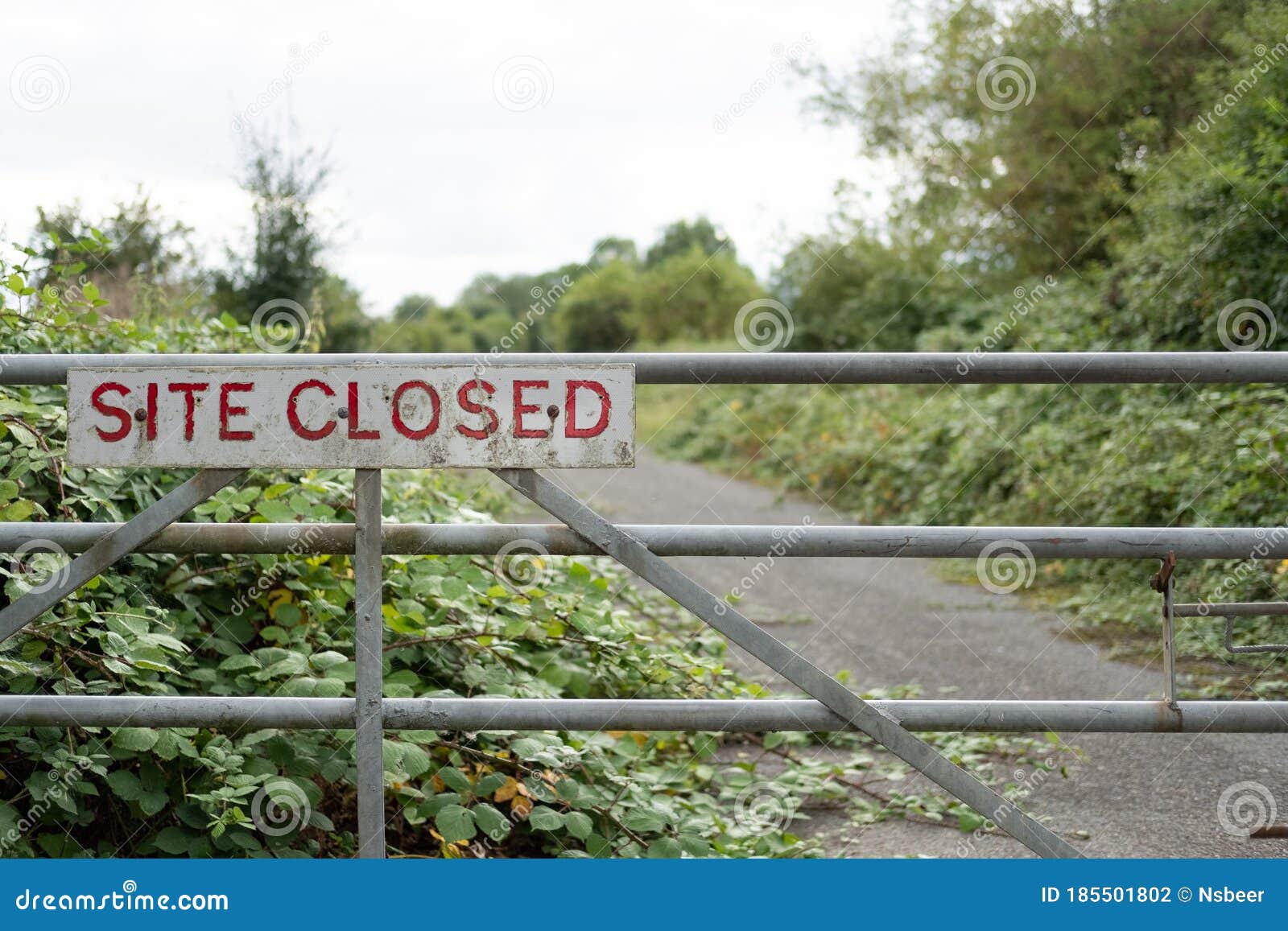 improvised-site-closed-sign-seen-entrance-to-once-busy-factory-vegetation-starting-take-hold-access-road-beyond-185501802.jpg