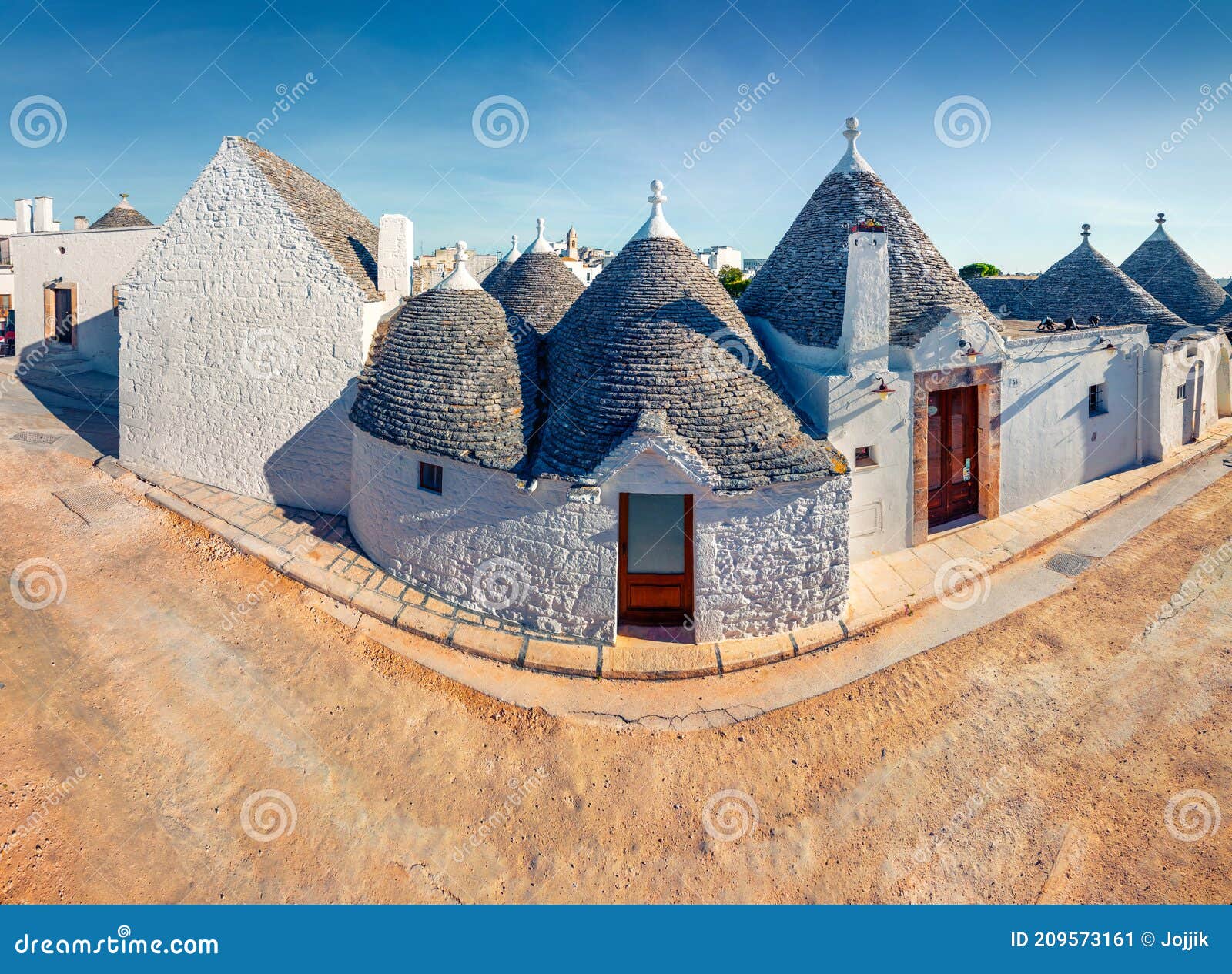 incredible morning view of strret with trullo trulli -  traditional apulian dry stone hut with a conical roof. sunny spring city