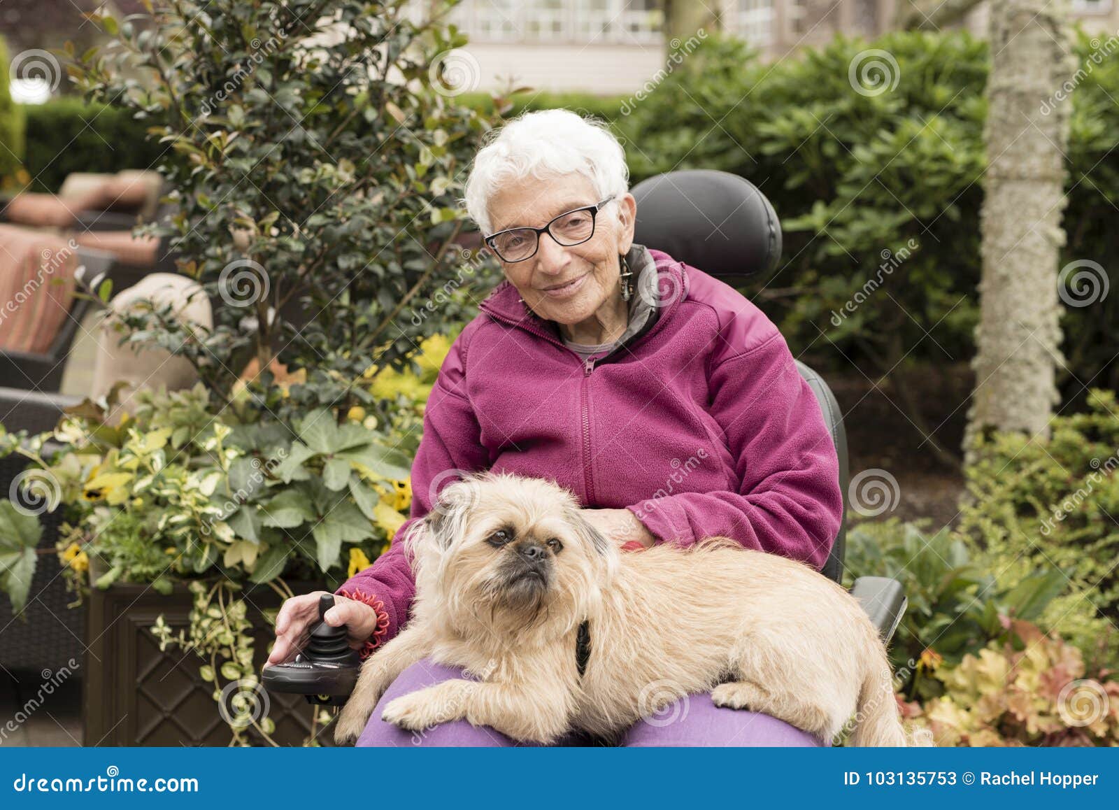 independent elderly woman outside in wheelchair with dog
