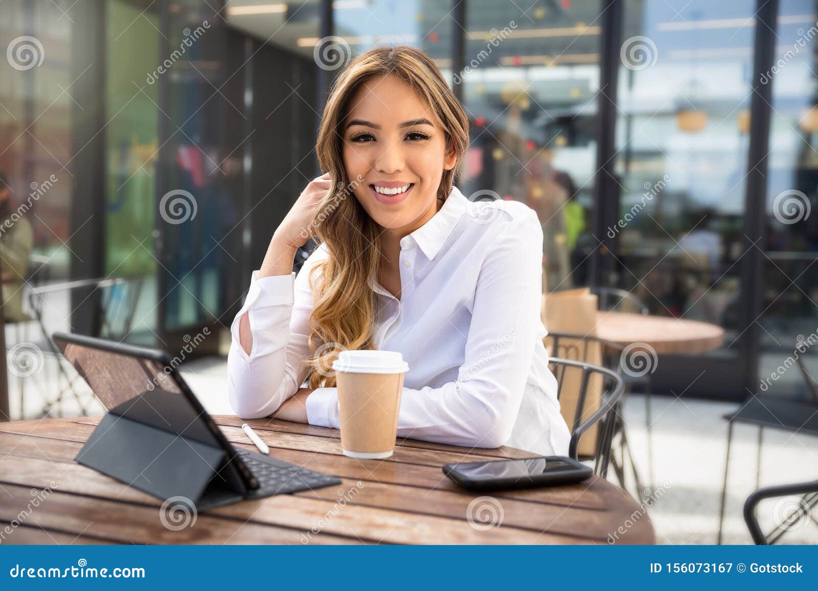 independent multiethnic female entrepreneur, web business owner, young self-employed professional working from laptop at coffee sh