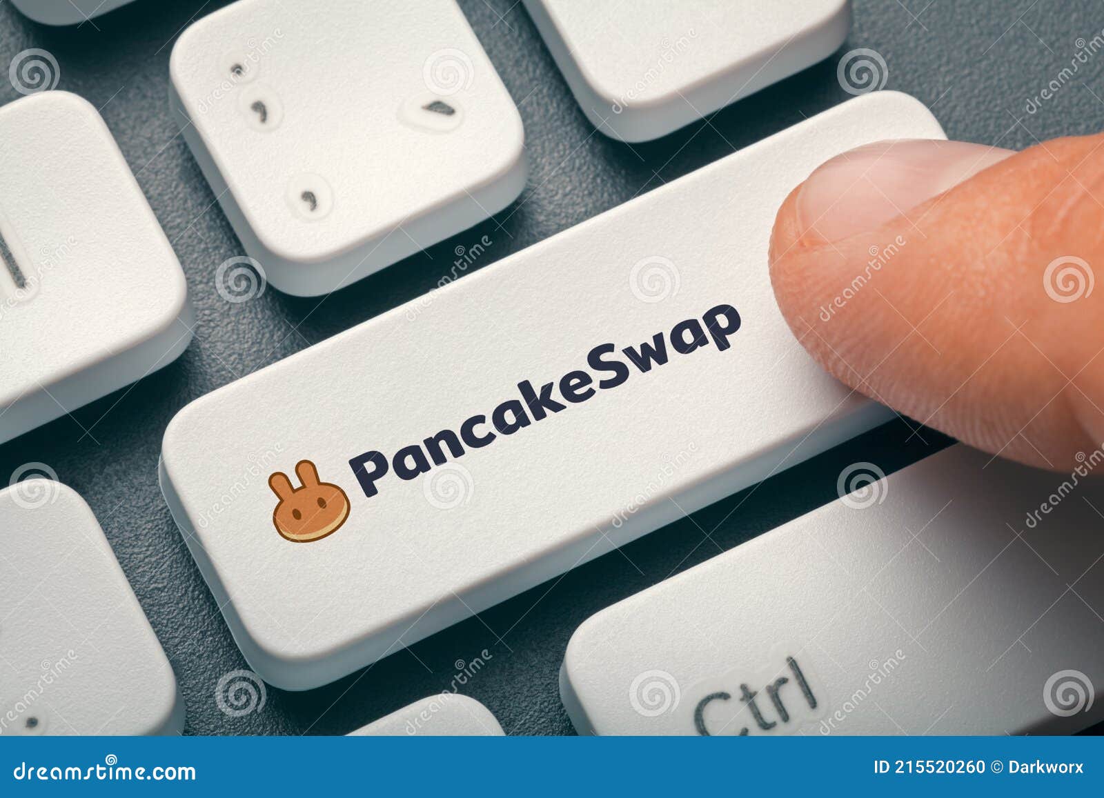 index finger pressing computer key with pancakeswap altcoin logo