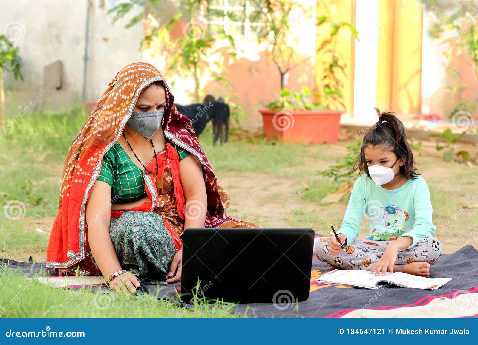 indian rural mother teaching daughter online on laptop using internet.