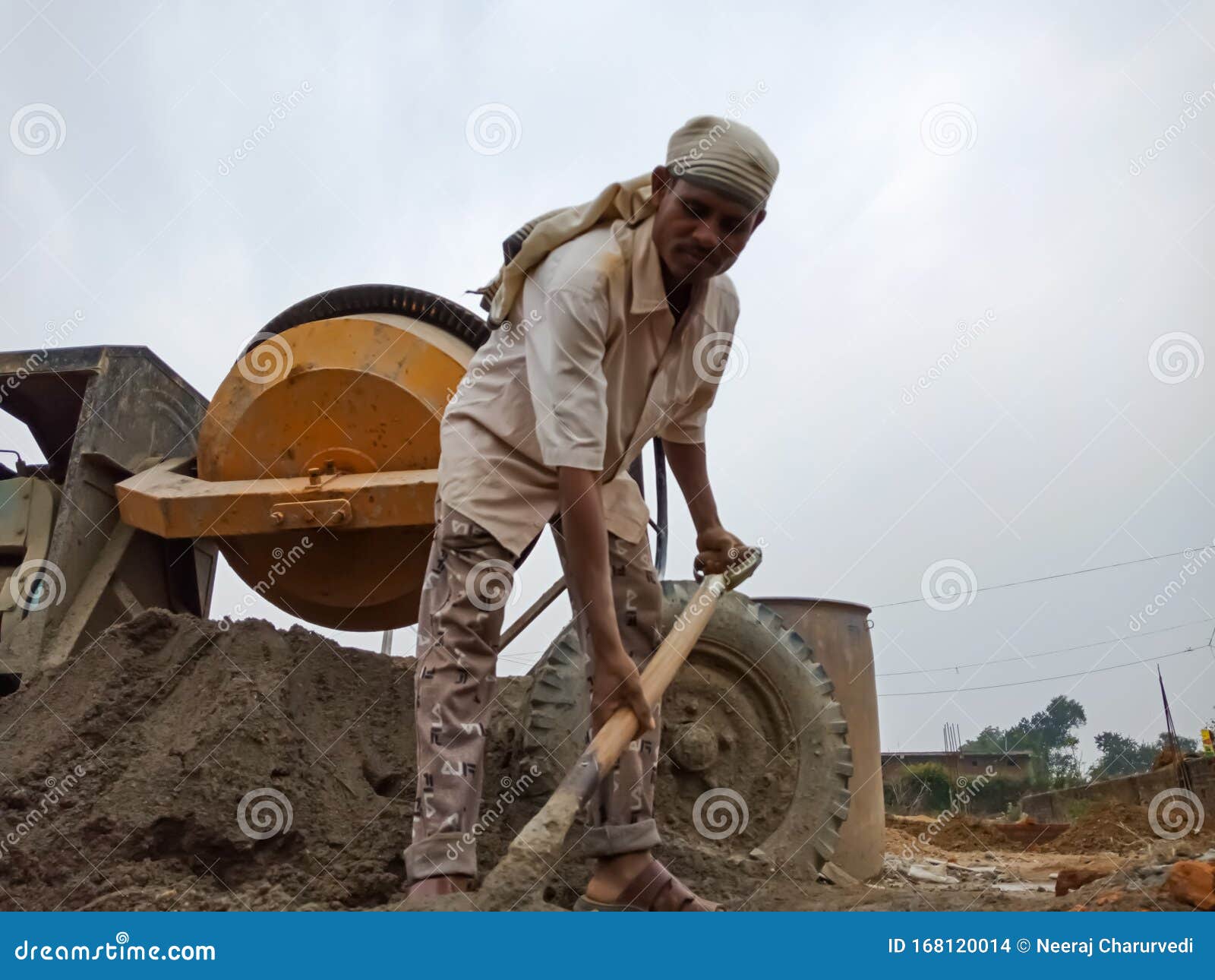 An Indian Construction Worker Making Building Material From Spade On Sky Background In India Dec