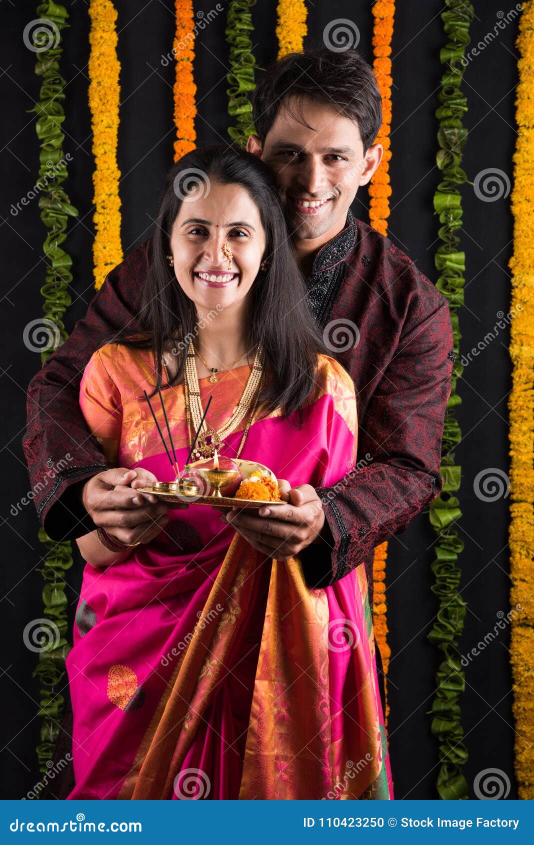 Smart indian couple in traditional wear performing gudhi padwa puja, asian  couple & puja thali, indian young couple with puja or pooja thali, hindu  new year gudhi / gudi padwa, isolated Stock