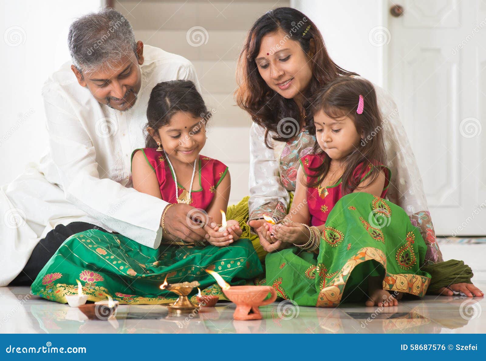 Premium Photo | Indian young family making flower rangoli or arranging  diyas for diwali festival night at porch with gifts and bokeh in the  background