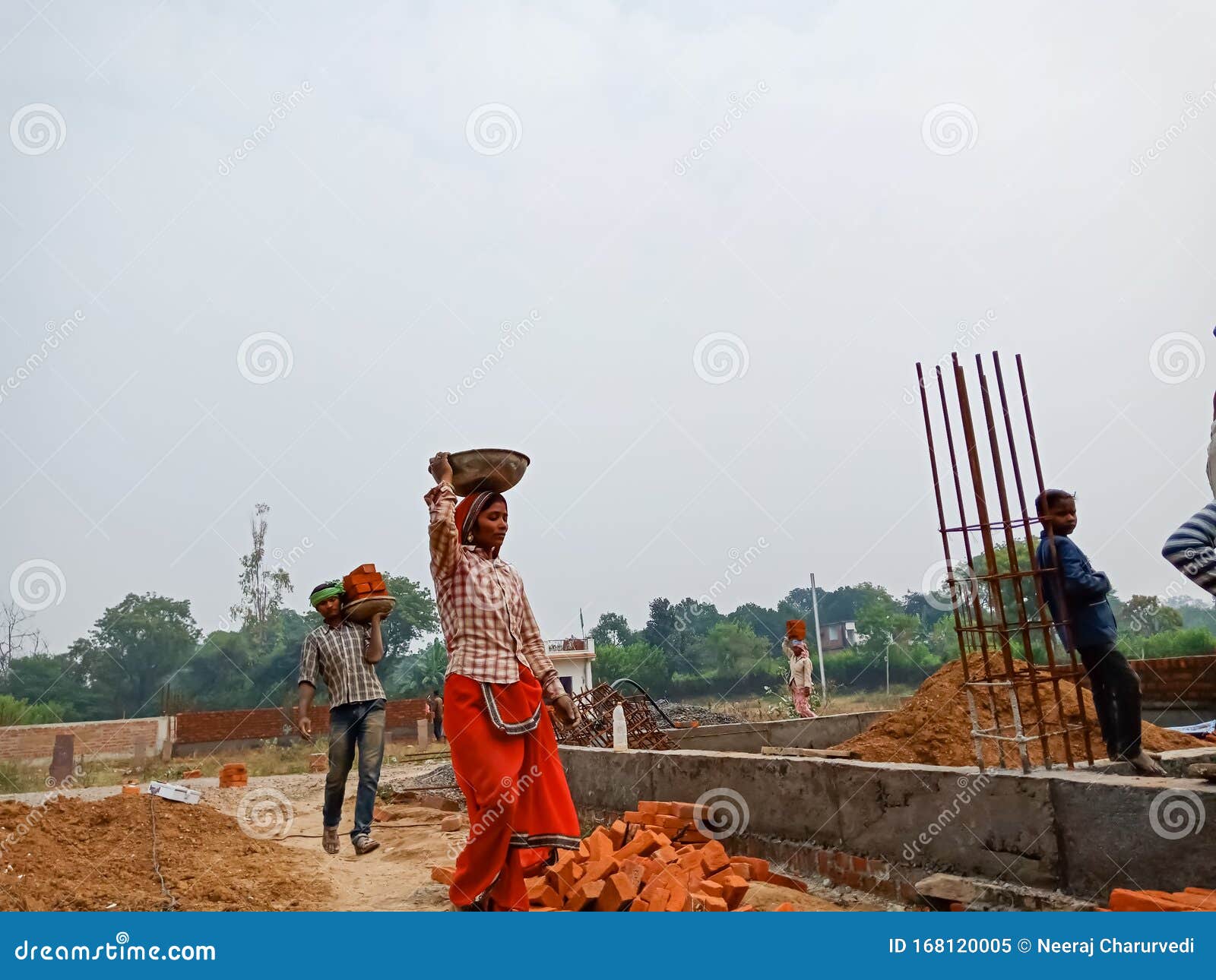 An Indian Female Labour Transporting Building Materials on Head during