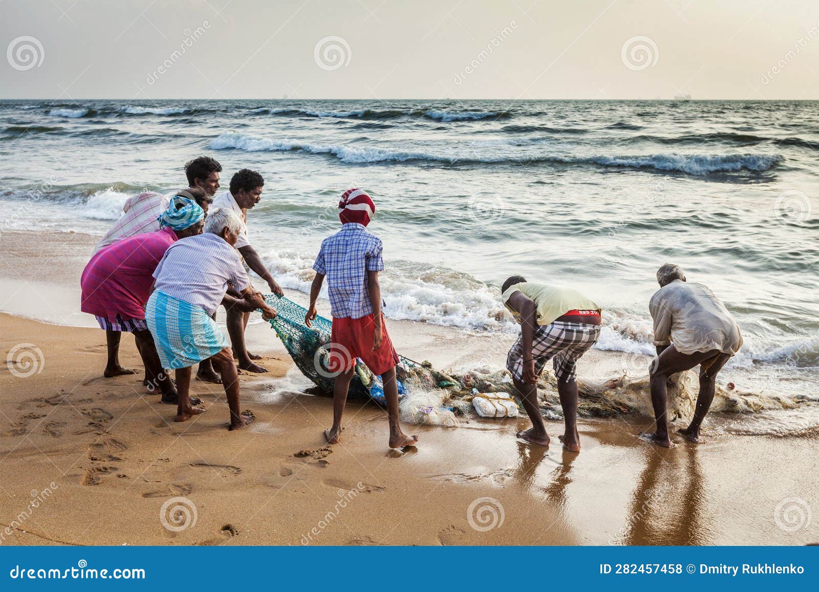 Indian Fishermen Dragging Fishing Net with Their Catch from Sea on
