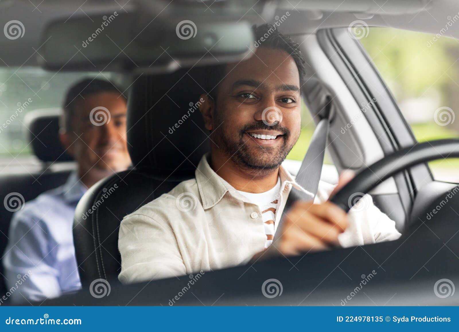 indian male driver driving car with passenger