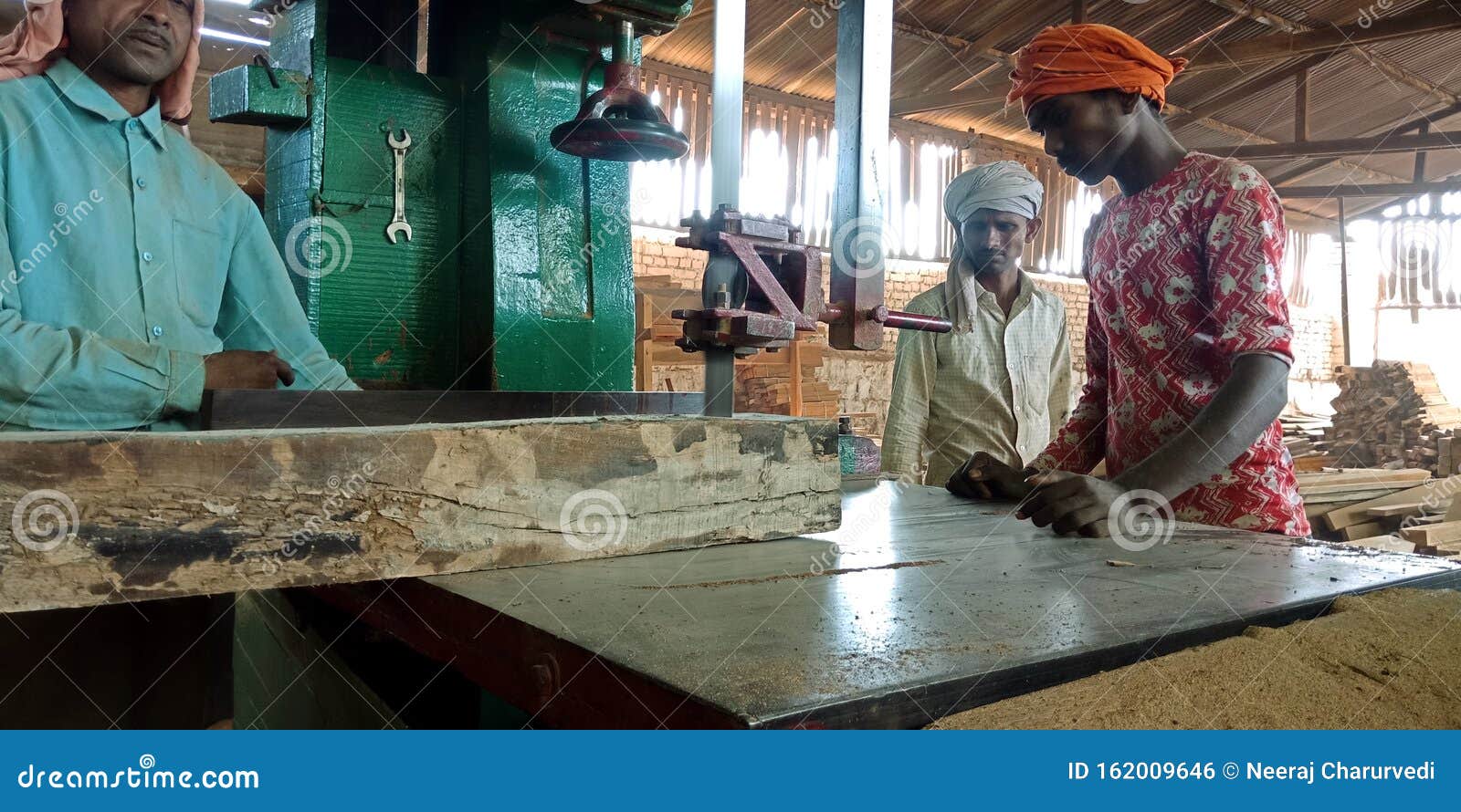 Indian Sawmill Workers Chopping Raw Wood from Electric Chopper