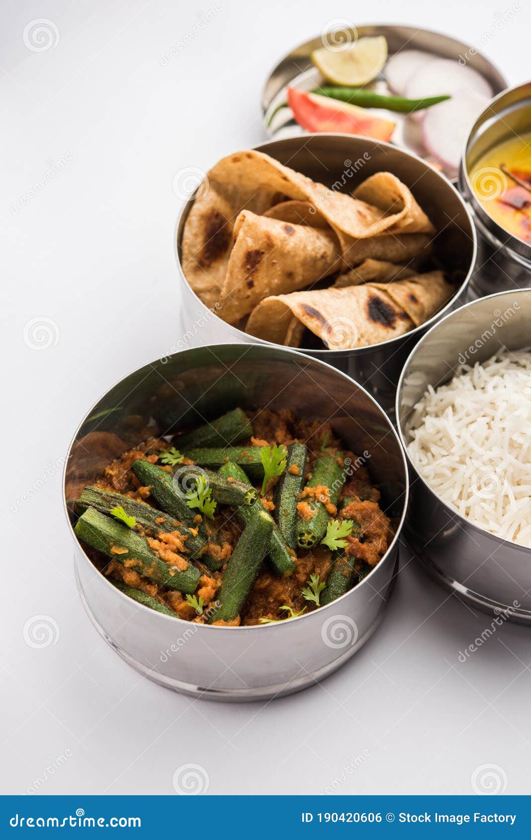 indian lunch box or tiffin - spicy ladies finger, dal fry, rice and chapati