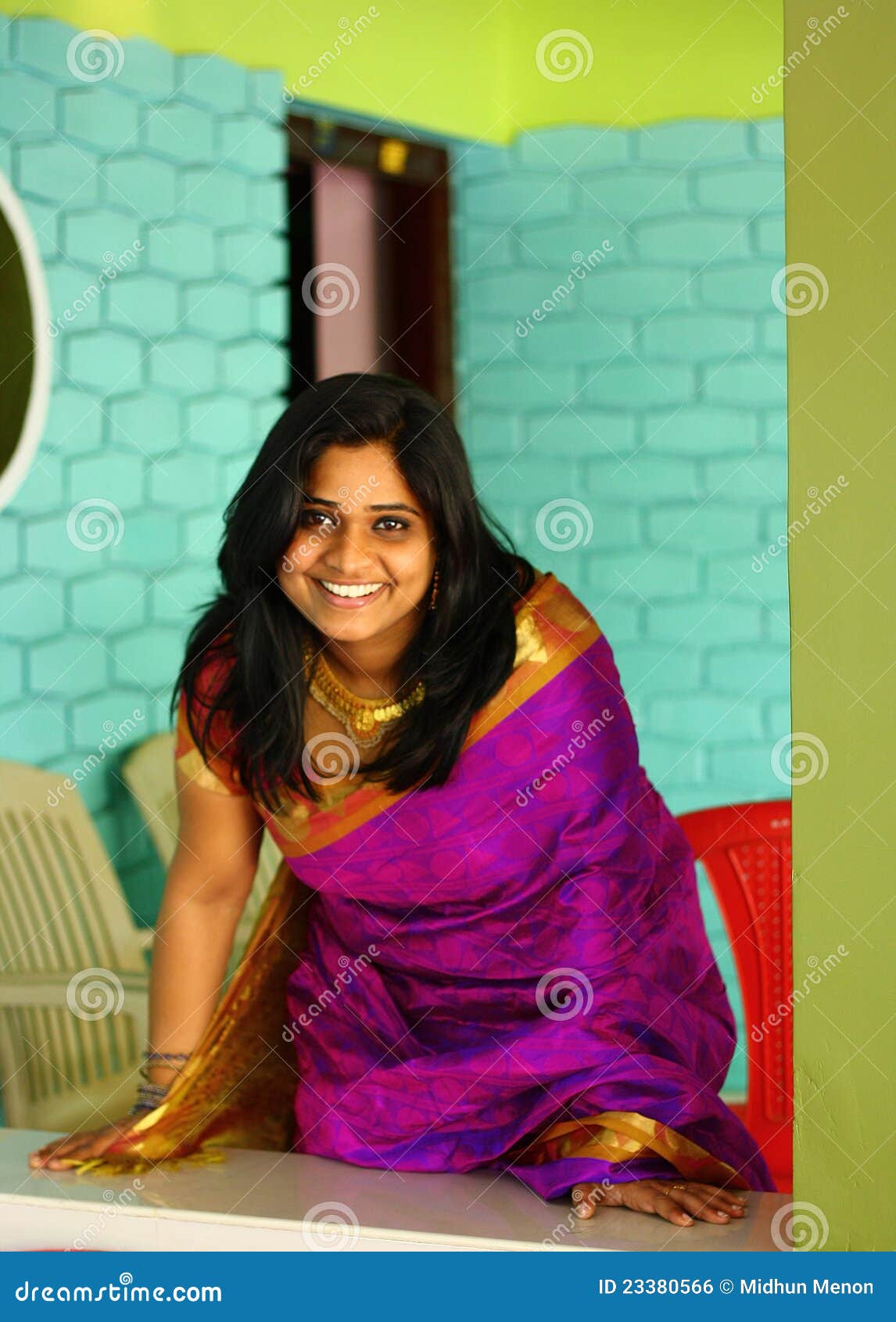 indian woman in purple saree bending and standing