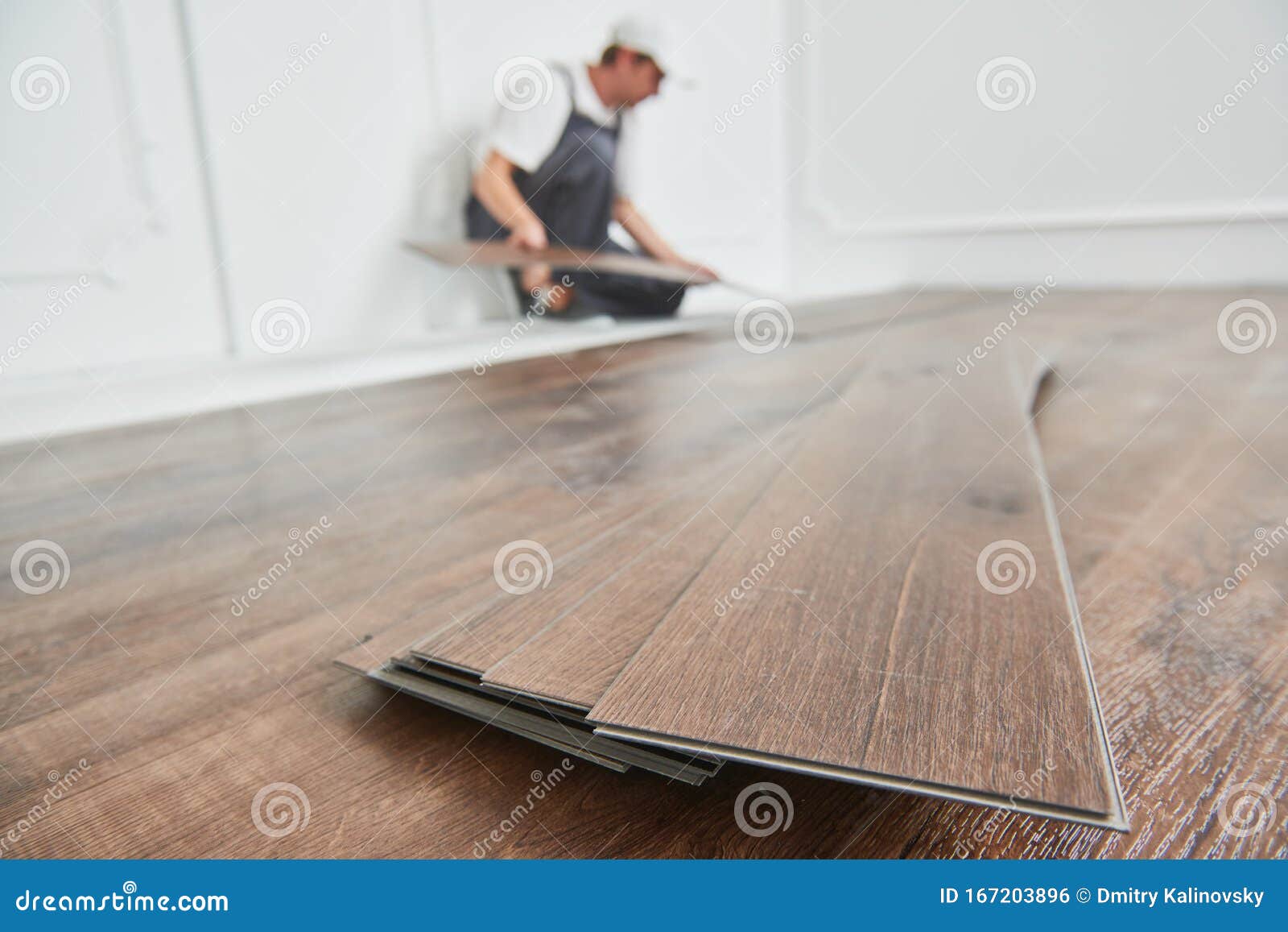Worker Laying Vinyl Floor Covering At Home Renovation Stock Photo